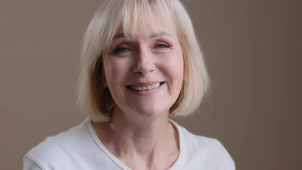 Happy Mature Middleaged Blonde Smiling Caucasian 60s Woman Looking at Camera Posing in Studio