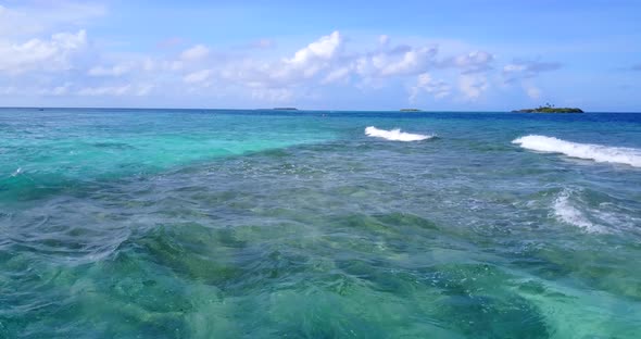 Natural above travel shot of a white paradise beach and blue sea background in 4K