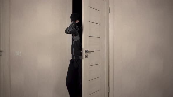 The Robber Climbed Into the House. The Masked Bandit Neatly Went Through the Door To the Room Aiming