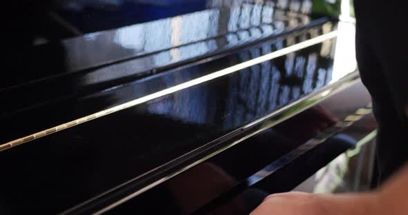 A musician opening the keyboard of a piano instrument to play notes at a concert