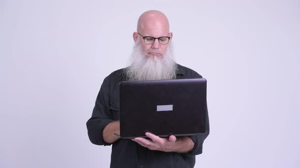 Mature Bald Bearded Man Using Laptop