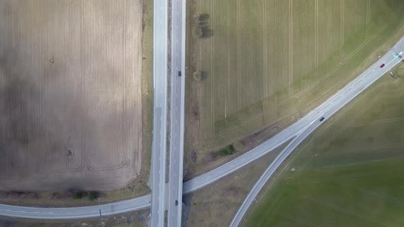Top down aerial view of highway intersection with moving traffic cars. 