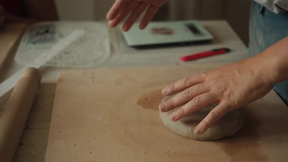 Front View of Female Potter Kneading Softly Clay on Worktop with Her Hands