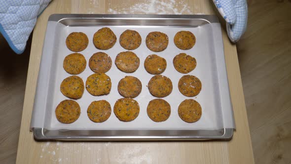 Hands Of Cook Put On The Table A Baking Tray Of Finished Cookies From The Oven