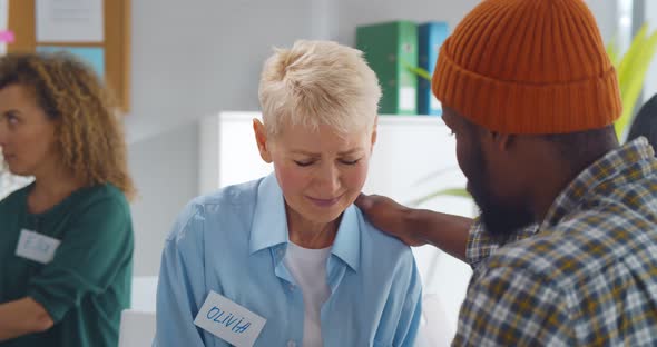 Psychologist Comforting Depressed Aged Woman During Therapy Session