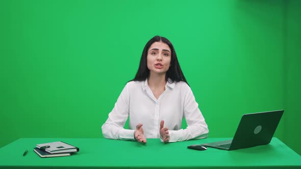 Woman Reporter Sits in the Studio and Looks Into the Camera Speaks and Hosts a News Programon a