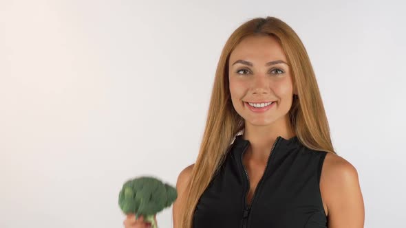 Cheerful Healthy Beautiful Woman Holding Broccoli, Showing Thumbs Up