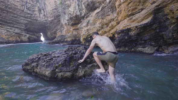 Adventurous young man in sea cave.