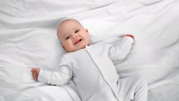 Top View Toddler Lying on Bed Laughing Having Positive Emotion