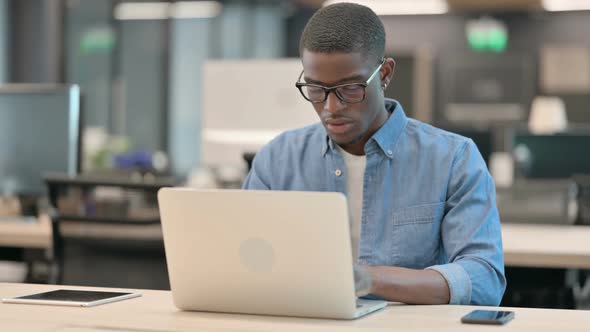 Young African American Man Having Back Pain at Work