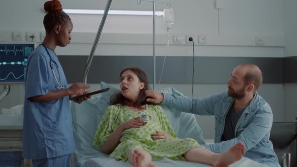 African American Nurse Assisting Pregnant Woman