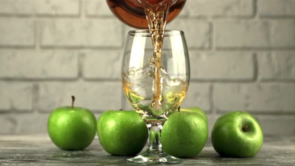 Super Slow Motion Apple Juice is Poured From Jug Into a Glass