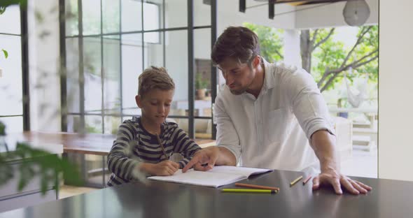 Father helping his son in homework at home 4k