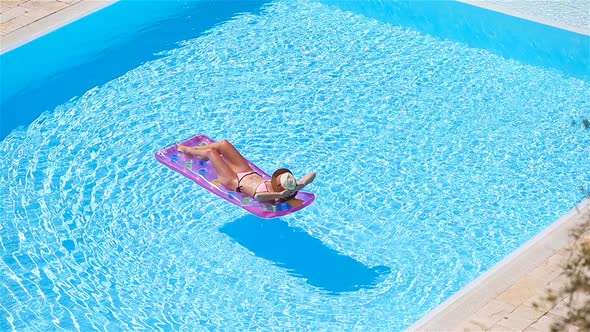 Young Woman in Bikini Air Mattress in the Big Swimming Pool