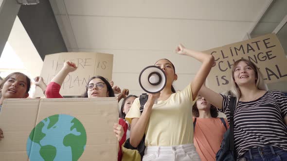 Multiethnic Group of Teenagers at a Protest March Carrying Signs with Environmental and Conservation