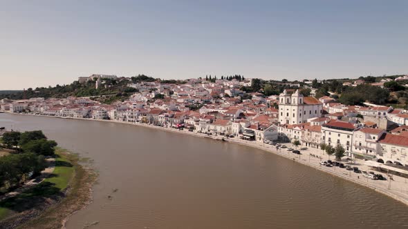 Alcacer do Sal bridge against riverside cityscape, Portugal, Fly over Sado river.