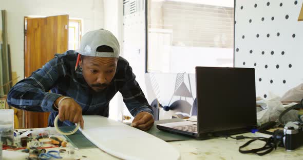 Man sticking sellotape on skateboard