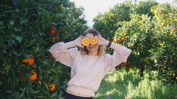Young Pretty Woman Holding Oranges in Front of Her Eyes