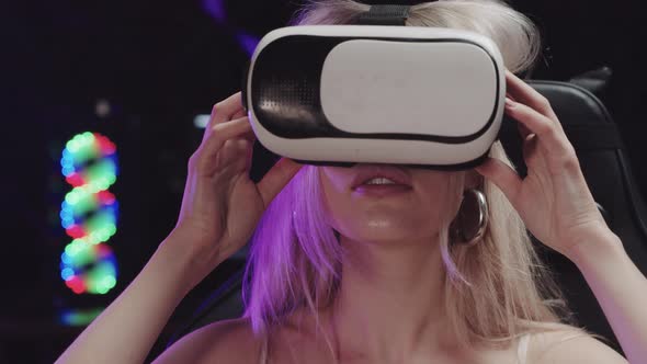 Attractive Blonde Gamer Girl Putting on VR Glasses