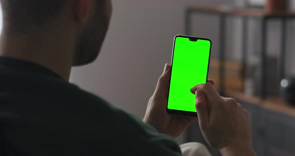 Man Is Browsing Internet Site Swiping Pages Holding Smartphone Vertically Green Screen Technology