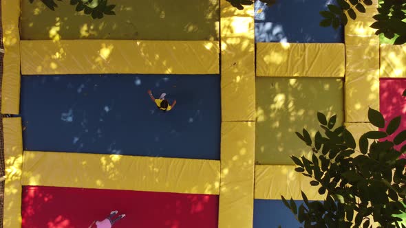 Two Little Girls in the Summer Jump on a Trampoline Smiling and Laughing