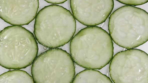 Motion Shot of Splashing Water on Rotating Cucumber Slice