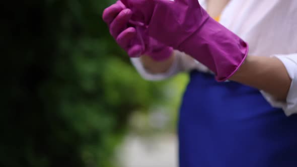 Closeup Plussize Female Caucasian Hands Putting on Pink Gardening Gloves in Slow Motion