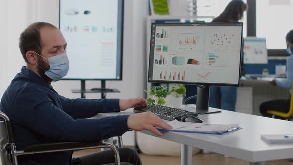 Immobilized Man with Protective Mask Working in New Normal Company