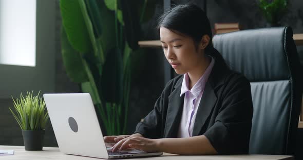 Asian Businesswoman Working on Laptop Computer at Home Office