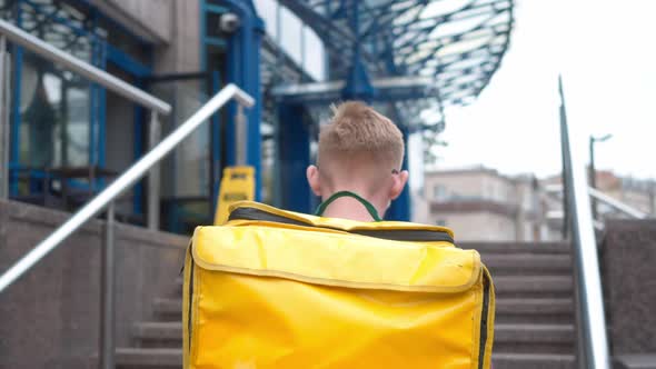 Live Camera Follows Yellow Insulated Food Delivery Bag As Male Courier Walking Upstairs to Business