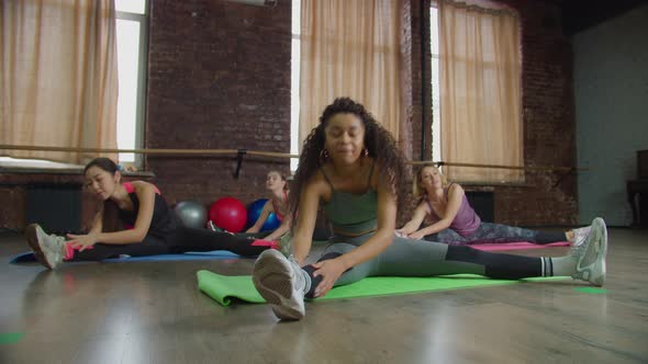 Diverse Fit Women Doing Seated Toe Touch Stretch