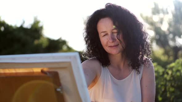 Female Artist Painting a Colorful Painting Outdoors