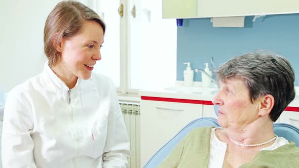 Close up of female dentist and elderly female patient talking