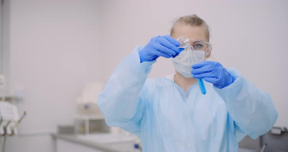 Female Scientist Holding Tubes and Flask with Liquid in Hands alt