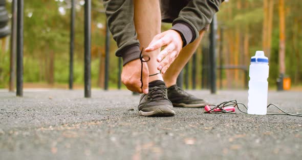 Closeup  a Man Tying His Shoelaces on Sneakers Before an Outdoor Workout