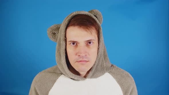 Unhappy Man in Hood with Ears Looking at Camera on Blue Background