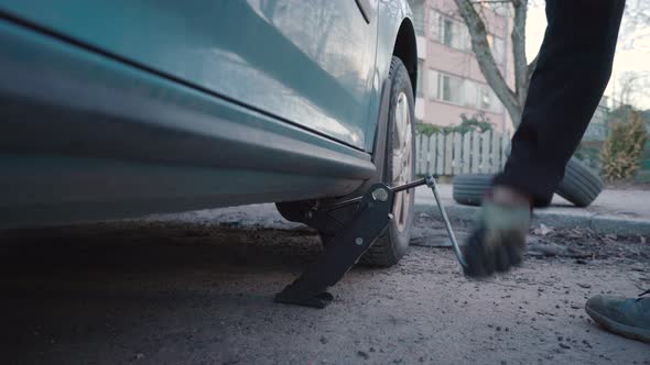 Man jacking up a car. Tyre changing process