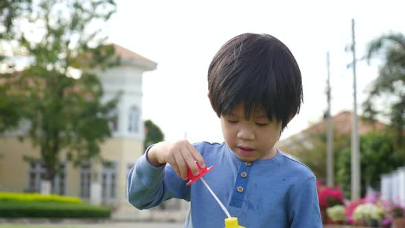 Cute Asian Child Is Blowing A Soap Bubbles