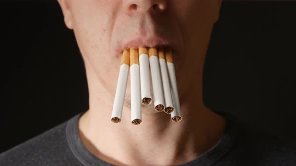 Few Cigarettes In Mouth Of Young Adult Hang Down