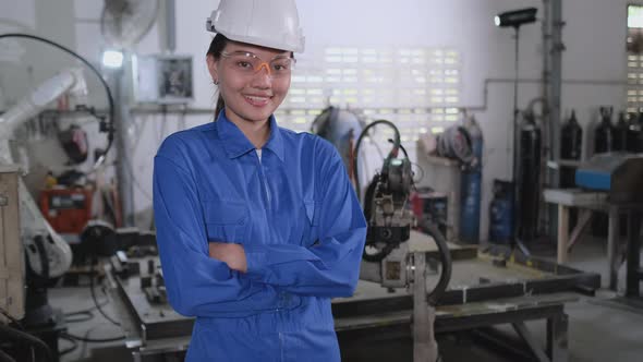 Portrait of factory worker woman or technician stand in front of robotic machine