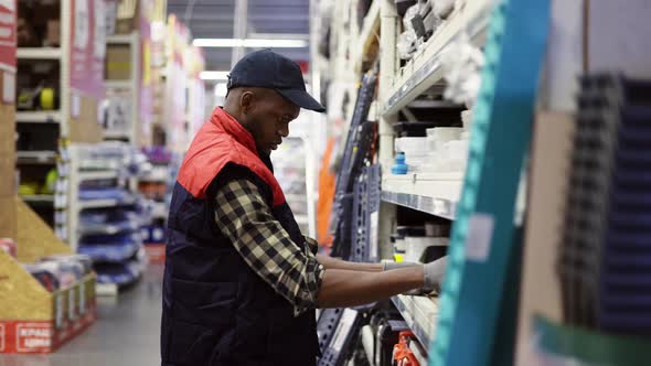 Male Supervisor Arrange Goods on Shelves of Hardware Store Side View