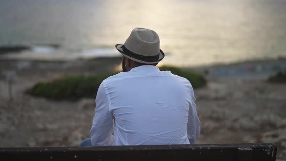 Back View of Calm African American LGBT Man Admiring Sunny Path on Mediterranean Sea Water Sitting