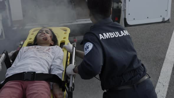 Paramedics Running on Road with Girl Lying on Stretcher