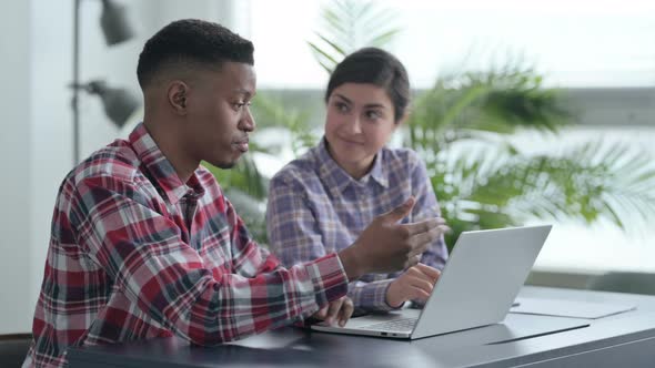 African Man and Indian Woman having Group Discussion on Laptop