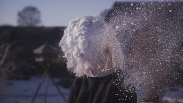 Cheerful Young Boy Laughing And Snow Thrown in His Face While Enjoying Winter