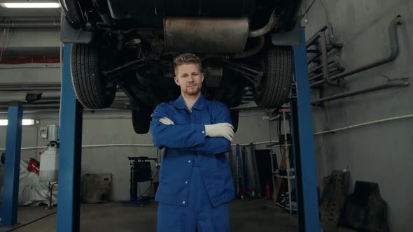 Portrait of a Young Beautiful Car Mechanic in a Car Workshop in the Background of Service