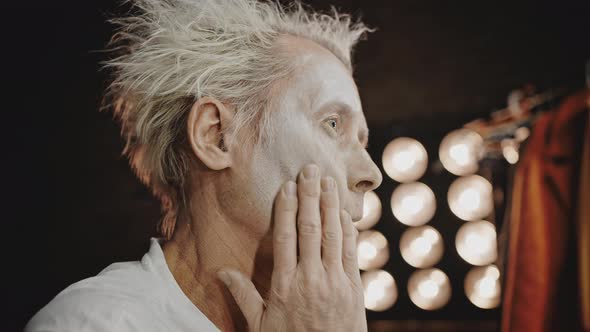 Mime Smudges White Paint Over Face for Performing at Show