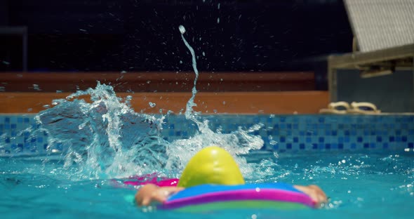 A Cute Little Child in Swimming Caps Performs an Assignment in a Swimming Lesson in the Pool