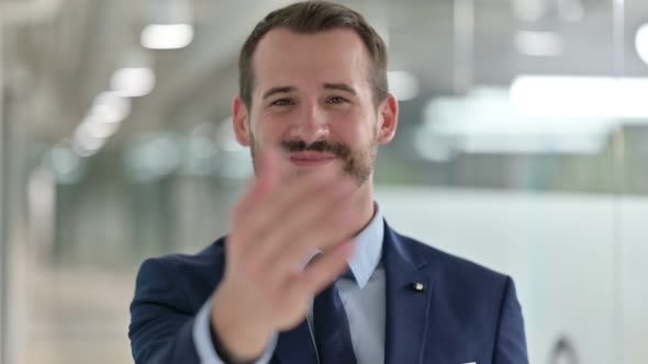 Portrait of Businessman Pointing Finger and Inviting 