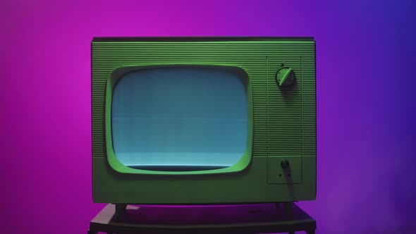 Old Vintage Television on Purple Neon Background Closeup